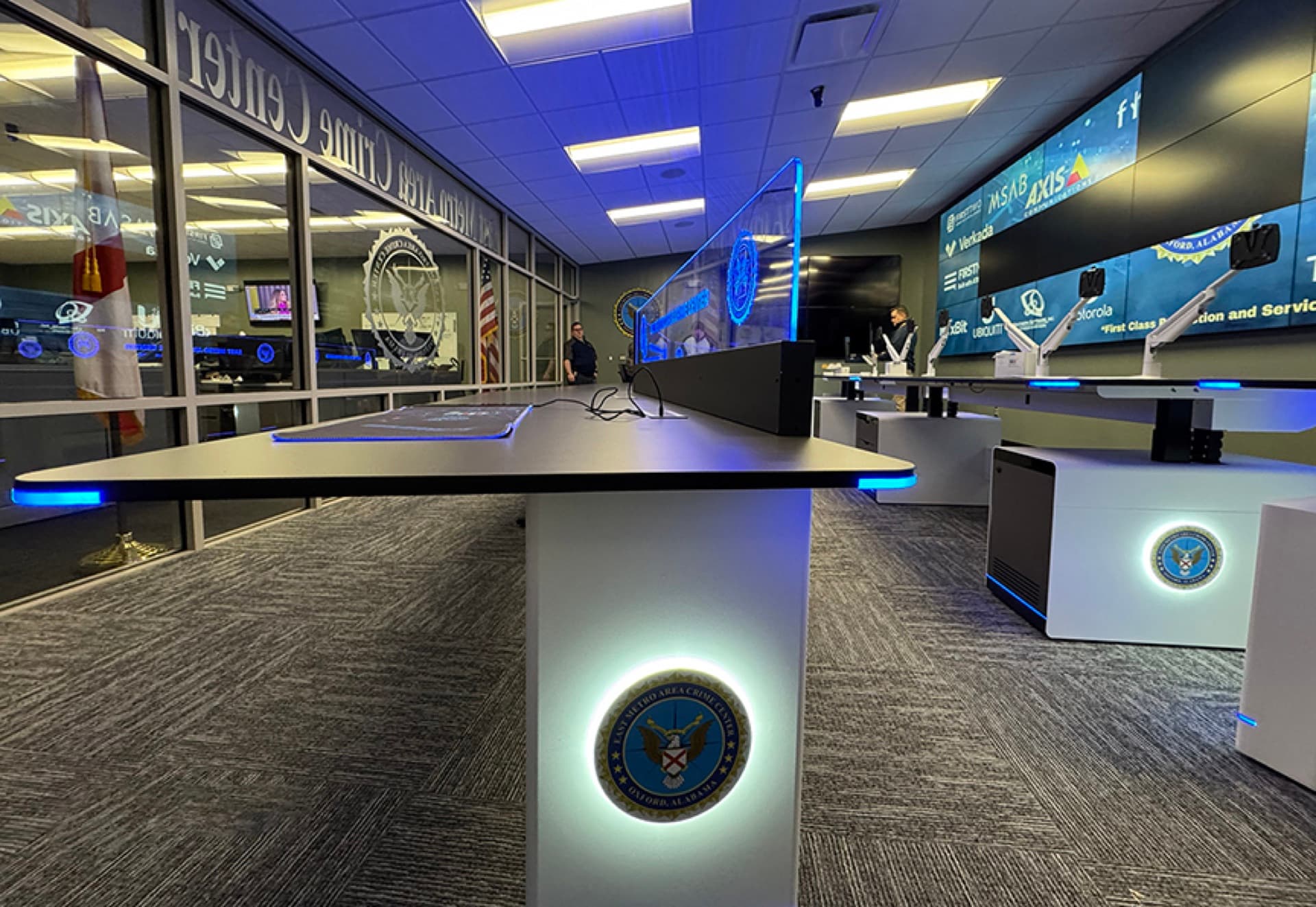 Public safety console furniture with illuminated department seals in a police real-time crime center
